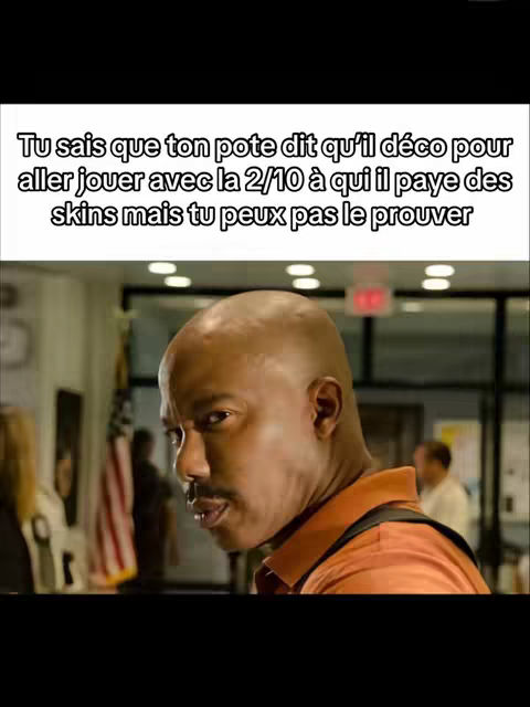 The image shows a close-up of a man looking over his shoulder, with text overlaid at the top. The man has a shaved head, a mustache, and is wearing an orange shirt or polo. Behind him, a blurred interior with a wooden or metal panel is visible, and the US flag. The color palette is mainly neutral, with the orange shirt providing a strong contrast.