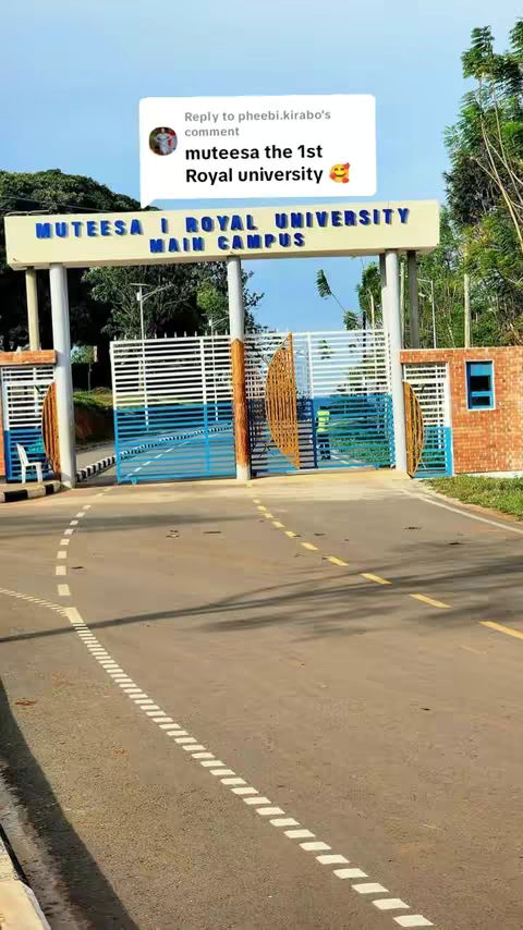 The image shows the entrance to a university. The entrance has a sign with the name of the university written in large, blue letters. There’s a comment from a user overlayed on the image indicating the name of the university. The entrance road leads into the distance, with green trees and blue sky in the background.