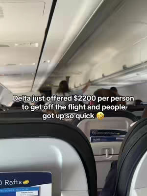 An interior shot of an airplane, focusing on seating and overhead compartments. Text is layered over the image, detailing an offer of $2200 to passengers to disembark, with a smiley face.