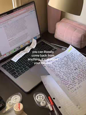 The cover image shows a laptop with a screen displaying text, a piece of paper with handwritten notes lies beside the laptop, and several desk items scattered around. A text overlay provides a motivational quote.