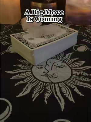 The cover image shows a table covered with a dark fabric patterned with white sun and moon symbols. A white box, possibly a tarot card box, is placed on the table. The text overlay reads, 'A Big Move Is Coming.'
