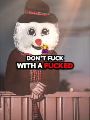 The cover image features a person wearing a snowman costume, with the head taking up most of the frame. The snowman has a white, rounded head with large visible eyes, a carrot nose, and a red button-like mouth. A black hat with a plaid band sits atop the costume's head. The costume has a brown shawl and a plaid scarf. Text overlays the image: "DON'T FUCK WITH A FUCKED" in bold, white letters with a red accent on the word "FUCKED". The background is a blurred outdoor scene, and an emoji hovers under the text.