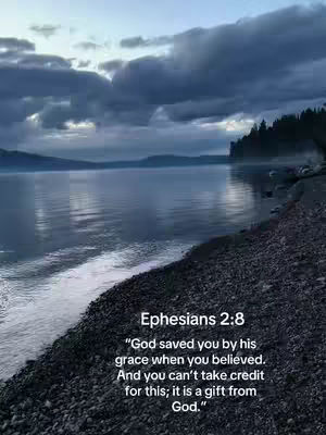 A serene waterscape with a calm lake under a cloudy sky, and text overlaying the image at the bottom. The water reflects the sky, creating a tranquil ambiance, with a rocky shoreline on the right and a forested area in the background.