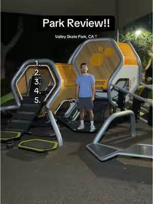 A man stands in front of a skate park structure at night. The structure is primarily yellow and brown with silver accents. Text overlays indicate the video is a park review and list numbered items down the side.
