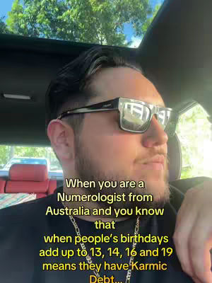 A man with sunglasses is seated in a car, with a tree visible through the sunroof. Text is overlaid on the image, with information about numerology topics.