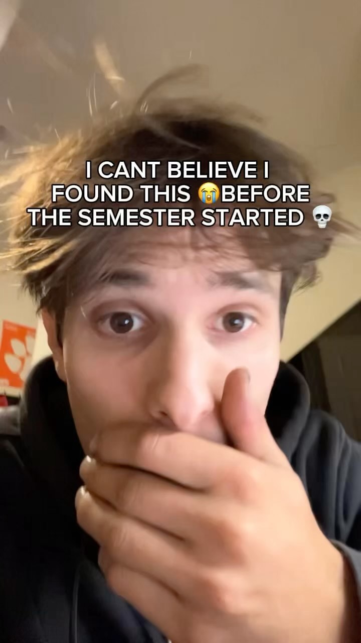 A young man with light brown hair is in a close-up shot, covering his mouth with his hand. The text overlay says 'I CANT BELIEVE I FOUND THIS 😭 BEFORE THE SEMESTER STARTED 💀