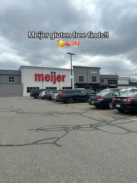 The cover image shows a daytime view of a Meijer store with cars parked in front. The sky is overcast. Text overlayed at the top says, "Meijer gluten free finds!!" with emojis.