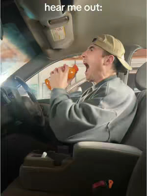 A man inside a car, holding up a bottle to his mouth and screaming. The lighting is natural, coming from the window of the car. The text overlay appears at the top, against the interior of the car.