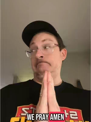 A medium shot of a man with glasses and a black cap looking upwards to the right with his hands together in prayer, and a lower text overlay.
