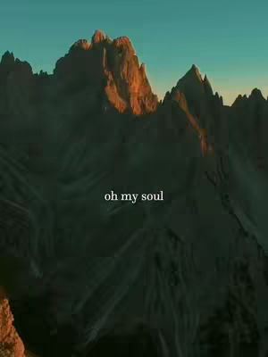 A landscape image showing a mountain range with a hazy atmosphere. The mountains are a mix of dark greens and browns, with the peaks lit by golden sunlight. Text overlayed at the bottom of the image reads, "oh my soul".