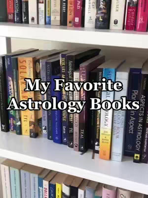 A shelf filled with various books, predominantly with dark spines and titles related to astrology. The books are arranged on a white shelf, and the lighting appears natural, highlighting the book spines. The text overlay is centered and bold, providing context for a video.