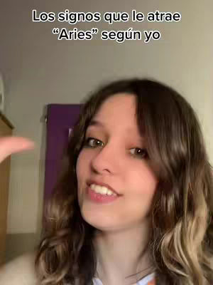A young woman with brown hair smiles at the camera. Text overlayed at the top reads, "Los signos que le atrae 'Aries' según yo". The background appears to be a room.