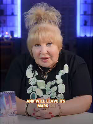 A woman with blonde hair in a bun and a black shirt is centered in the frame. She's sitting at a desk, and a small calendar is on the desk. The overlaid text at the bottom reads "AND WILL LEAVE ITS MARK ON". The background has a soft blue hue.
