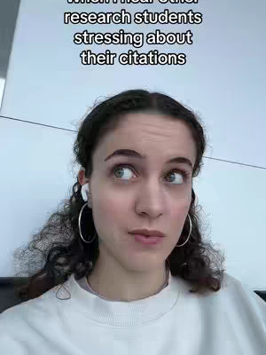 A young woman with curly brown hair and large hoop earrings gazes upward with a contemplative expression. She wears a white sweater and has eyeglasses in her ears. Text overlayed on the image reads, "When I hear other research students stressing about their citations."