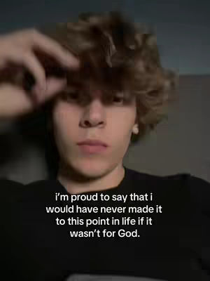 A young man with light brown curly hair looks directly at the camera, with his right hand near his head. Below the man, text is superimposed over the image.