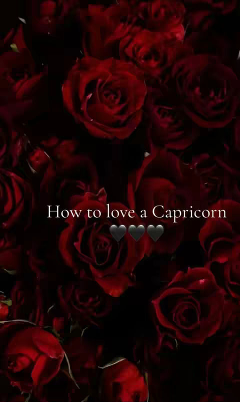 A close-up shot featuring a dark background filled with numerous red roses. Overlayed on the image is white text, reading "How to love a Capricorn", with three black hearts displayed below.