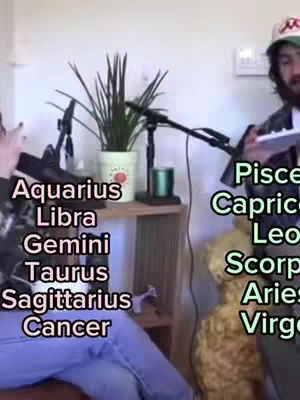 The image is a split visual taken indoors. On the left side, a person seated has their arms up towards the camera. Their left side is in the frame. Against a white wall is a list of zodiac signs. On the right side, a male figure holding a notebook or electronic device, wearing a hat. In the foreground is a stuffed animal. Additional text overlays include astrological signs.