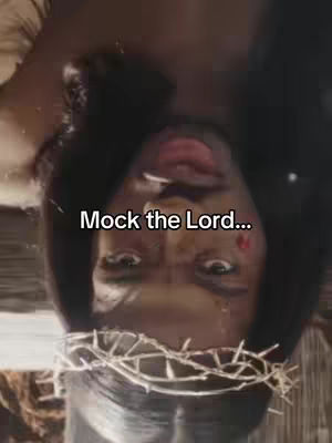 An upside-down portrait of a person with dark skin, seemingly in a mock portrayal of a religious figure. The person has a crown of thorns, suggesting a depiction of Jesus. The text overlay 'Mock the Lord...' appears in the image.