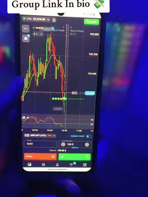 A smartphone displaying a trading app interface is held in a hand, with the screen showing a candlestick chart and trading data. The background is a gradient of dark blue and purple, suggesting a low-light environment.