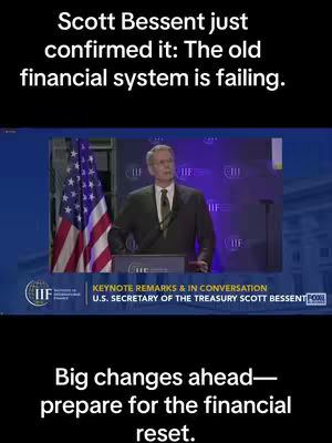 The image shows a man standing at a podium giving a speech, with text overlays. An American flag and the IIF logo are visible in the background. The upper text reads "Scott Bessent just confirmed it: The old financial system is failing.", and the lower one says "Big changes ahead — prepare for the financial reset."