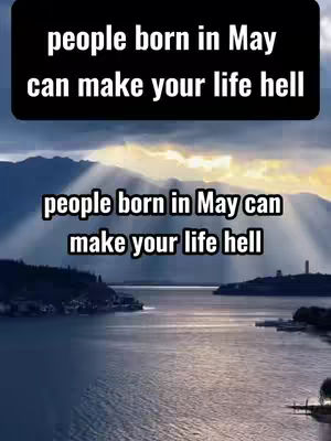 A scenic landscape with a lake reflecting the sky and mountains, overlaid with text in white font that reads 'people born in May can make your life hell'. The sky has a golden hue as light shines through the mountains.