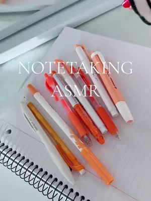 A close-up shot features notebooks and pens arranged on a white surface. The pens are primarily orange and white, creating a visually appealing arrangement. The composition suggests a focus on study aesthetics.