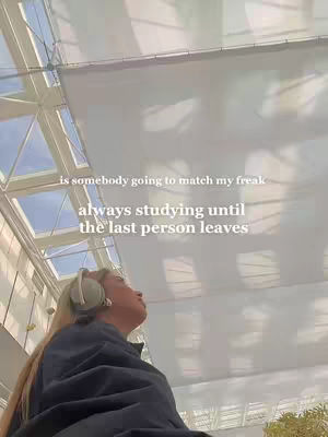 The image shows a person in the bottom left corner looking up, wearing headphones. The person is positioned below a light-filled ceiling with visible support beams.