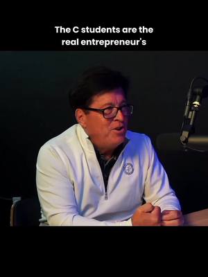 The video features a man speaking, with text overlayed at the top. He is in a well-lit setting, possibly a studio, with a dark background. A microphone is visible on the right. The man is wearing glasses and a white jacket and appears to be engaged in a discussion.