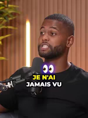 The cover image features a Black man centered in the frame, speaking into a microphone. Below his face, the text overlay reads "JE N'AI JAMAIS VU". The background is composed of vertical wooden panels, and a glowing light highlights the side of the man.