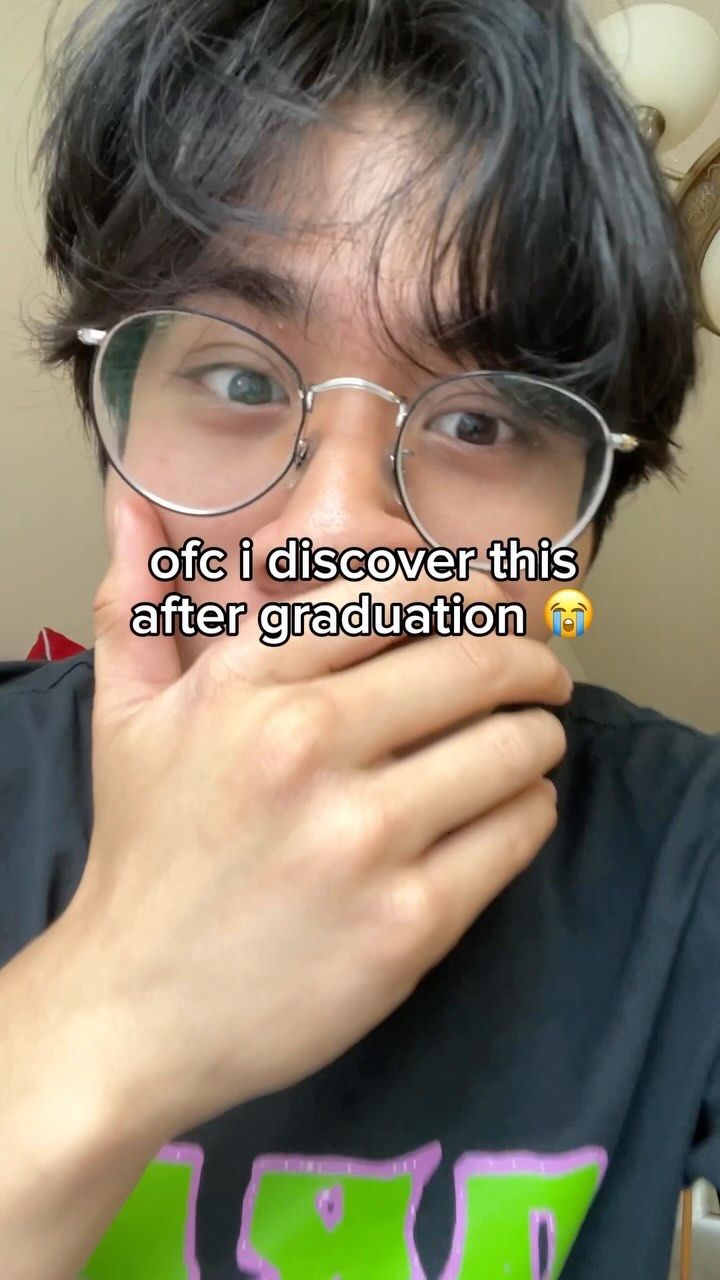 A close-up selfie shows a young man with dark hair and glasses, covering his mouth with his hand in a gesture of surprise or realization. Text overlays the image.