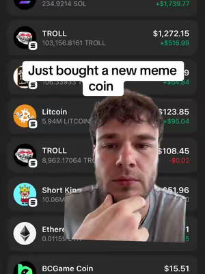 A vertical screenshot from a phone app showing different crypto currencies and their current value. Overlayed on the screen, the creator is positioned on the right showing his upper body and face. A text overlay says "Just bought a new meme coin". The background of the app is dark grey with the the same color code, highlighting the app’s listings.