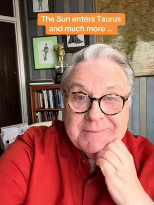 An older man with glasses and a red shirt is the main subject. He is inside a room, with the background including a bookshelf and paintings. Overlay text identifies the content.