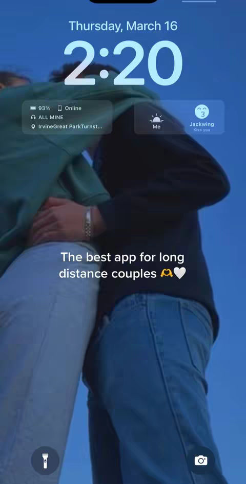 The cover image shows the lock screen of a phone angled to show two people embracing. The top displays the time and date with app info. Overlayed at the bottom is text in white, above two embracing figures.