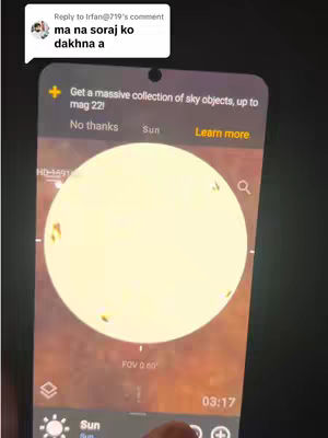 A person holds a phone displaying an app that shows a bright yellow circle representing the sun. The app interface includes selectable options and text overlays. A comment bubble and clock display are also present.