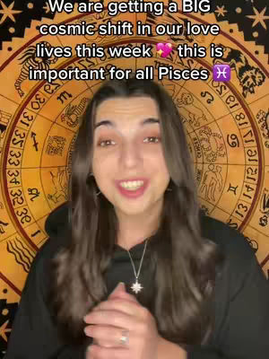 A woman with long brown hair is centered in the frame, smiling at the camera, with a zodiac wheel design visible in the background.