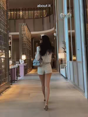 The cover shows a woman from the back walking down a hallway with tall windows, a light-colored floor, and high ceilings, with a text overlay.