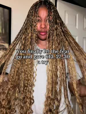 A woman with long braids framing her face smiles coyly while holding them out, with white text overlaid at the bottom.