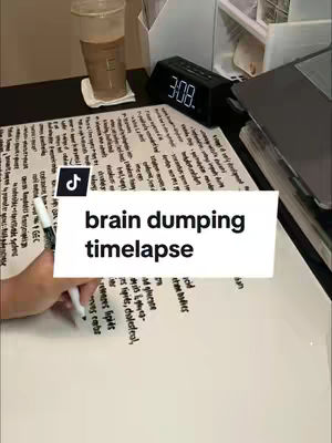 The image shows a desk setup with a whiteboard covered in handwritten notes, an iced coffee, a digital clock displaying 3:08, and a laptop. A hand is seen writing on the whiteboard with a marker. A TikTok logo and the text overlay are present.