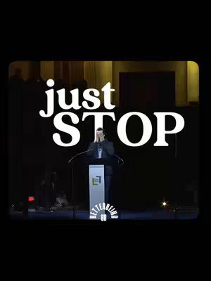 A motivational cover image showing a man on a stage in a dark setting with the words "Just Stop" in large white fonts, with a blurred background. The man is speaking at a podium.