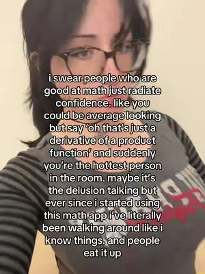A selfie-style video featuring a young woman with glasses and dark hair, set against a neutral background. She wears glasses and has dark hair which is slightly messy. Dark text overlay on the image.