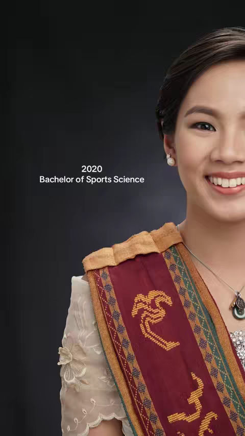 The cover image features a close-up of a smiling woman with a graduation sash. The background is a solid dark gray. The woman has dark hair, is wearing pearl earrings, and is smiling at the camera. She is wearing a dress or top with a lace overlay on one shoulder. The sash is maroon in color with decorative gold embellishments. Text towards the left side of the image reads, '2020 Bachelor of Sports Science.'