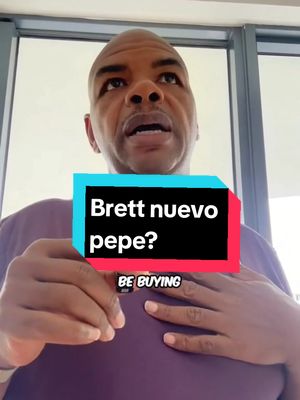 A man with short dark hair and a neutral to slightly concerned expression stands in front of a window. Overlayed on him is a rectangular graphic with the text 'Brett nuevo pepe?' in bold white letters on a black background, with red and blue highlights. Below it is 'BE BUYING'.