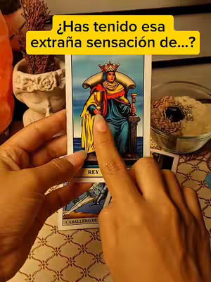 The cover image shows a person holding a tarot card in their hands, with another card visible underneath. There's a yellow banner across the top with white text. The background includes a blurred setting with a plant and possibly other objects. The lighting appears to be soft, and the color palette is warm, featuring yellows and oranges.