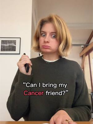 A woman with blonde hair and a dark green sweater holds a phone and looks at the viewer with a questioning expression. Text overlayed reads, “Can I bring my Cancer friend?”, with “Cancer” highlighted in pink. The background includes an off-white wall, a small framed picture, and a glimpse of a doorway.