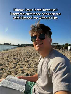 A sunny beach scene with a man in sunglasses holding an open book. Text overlayed indicates a religious message.