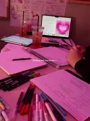 An interior shot features a laptop open on a desk cluttered with books, multi-colored pens, and two iced drinks. The scene is illuminated with a pink hue. A timer showing 4:29 is on the laptop screen. The text, 'Studying with your bestie >>' is also on the image.