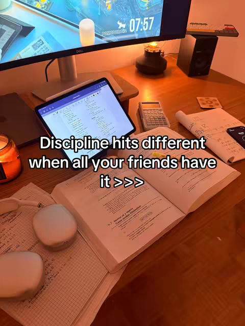 The image shows a desk setup with study materials. A computer monitor displays an interface at the top. An open book, papers, and a tablet are in the foreground along with two small white objects. Text is placed on the cover image.