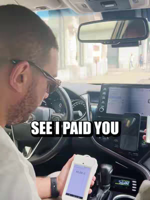 The cover image shows a man from the back in the driver's seat of a car, holding a payment device. The text overlay reads "SEE I PAID YOU." The interior of the car, including the dashboard, steering wheel, and a view of the street outside, is visible.