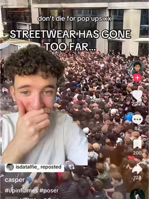 A young man in a white t-shirt is the visual focus, covering his mouth with his hand in a gesture of surprise or concern. He's positioned in front of a dense crowd of people, likely outdoors based on the building visible in the background. Text overlays on the top, with white text and black text on a black rectangle, draws attention to the crowd and event. The overall atmosphere suggests an event that got out of control.