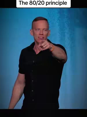 A man in a black shirt is pointing directly at the viewer against a light blue background. The image is framed from the chest up, focusing on the man's face and gesture. Above him, white text reads "The 80/20 principle".